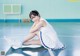 A woman sitting on a basketball court with her legs crossed.