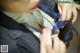 A woman in a business suit is tying up her tie.