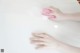 A person cleaning a bathtub with a pink sponge.