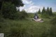 A woman sitting on a blanket in a grassy field.