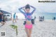 A woman in a pink bikini standing on a beach.