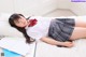 A woman in a school uniform laying on a bed.